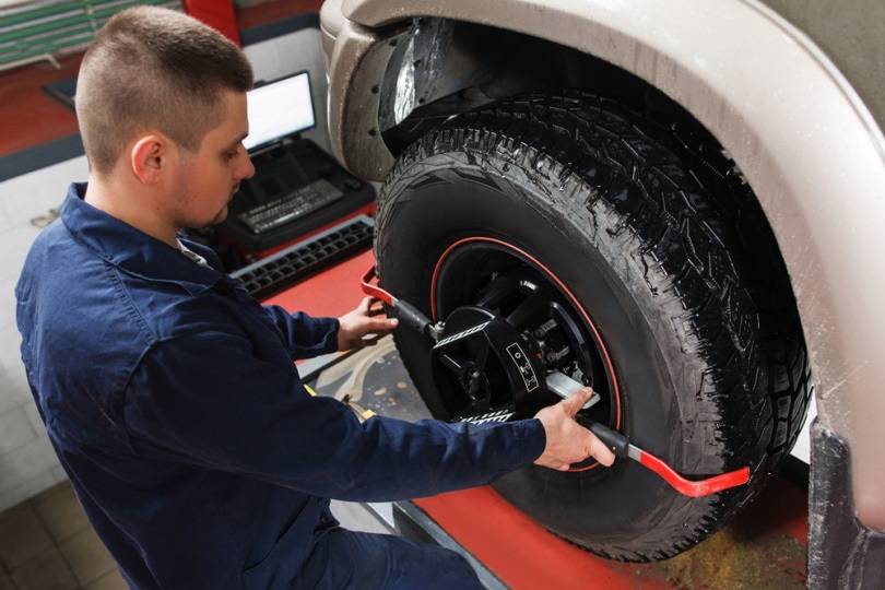 mechanic performing wheel alignment