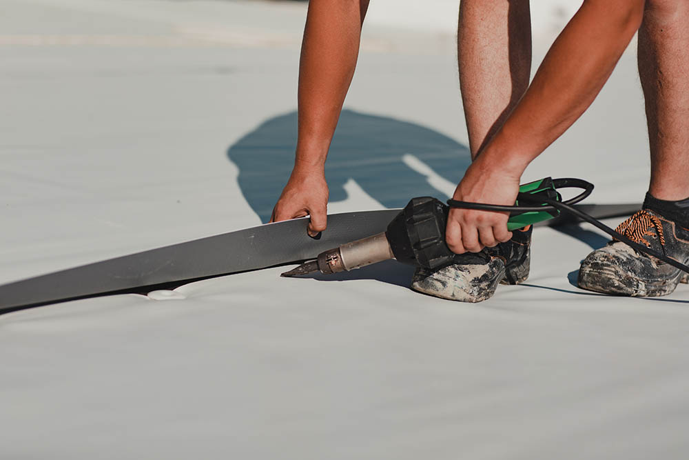 person installing TPO roofing