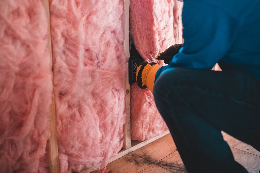 person insulating a wall