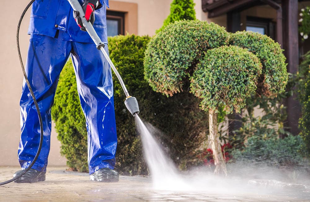 person pressure washing the driveway