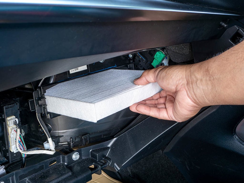 person replacing the cabin air filter