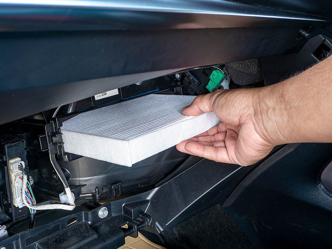 person replacing the cabin air filter