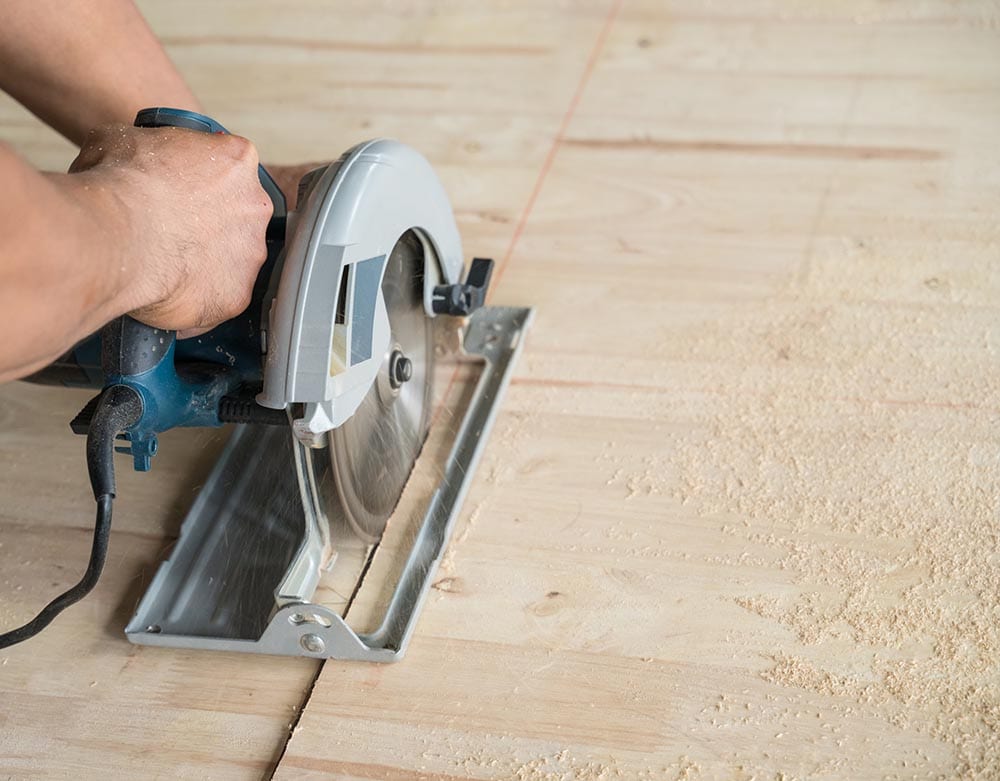 person using handheld worm drive circular saw