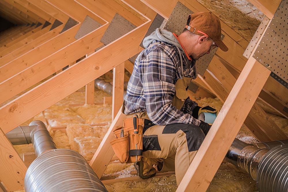 Professional installing attic fan ventilation system