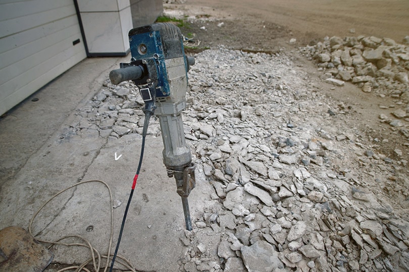 removing concrete floor with jackhammer tool