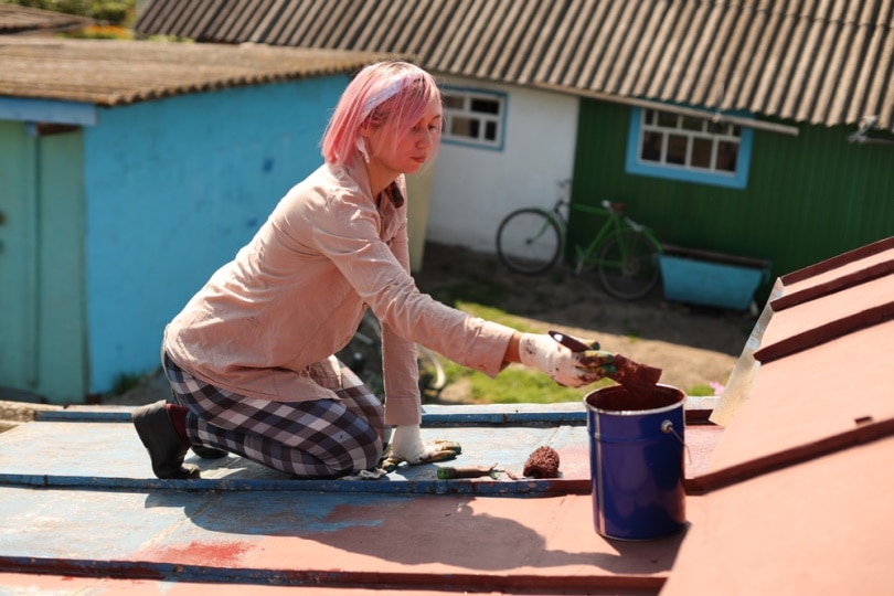 woman painting metal roof