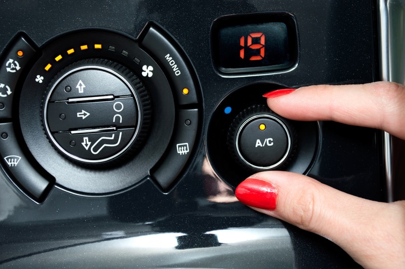 woman turn on car AC