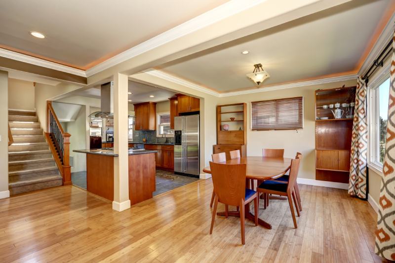 Craftsman kitchen and dining room combo with soft beige walls and hardwood floors