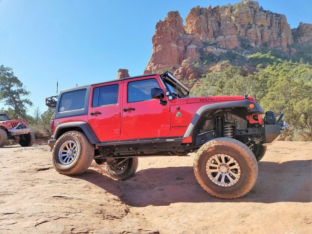 a lifted red jeep on the trails