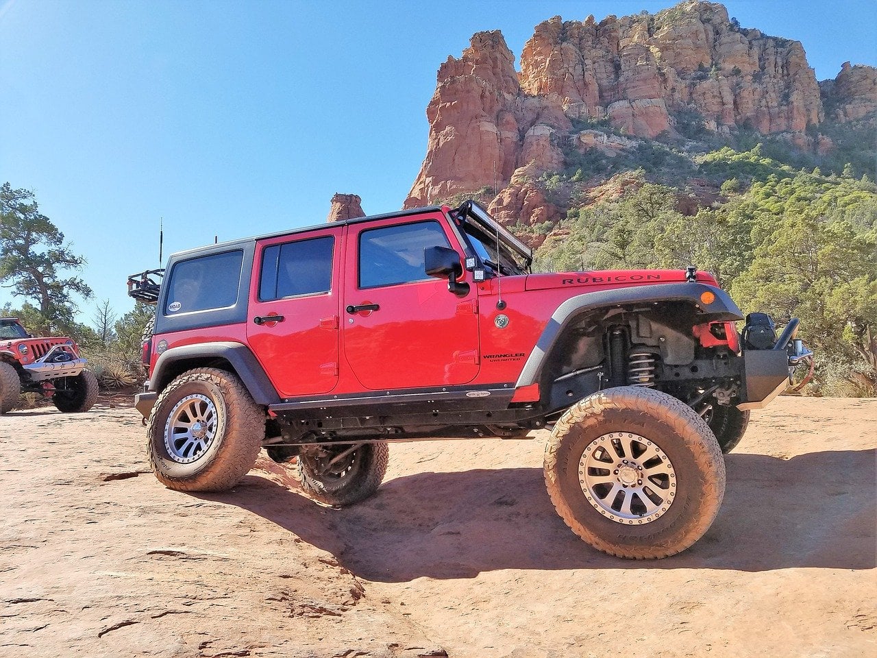 a lifted red jeep on the trails
