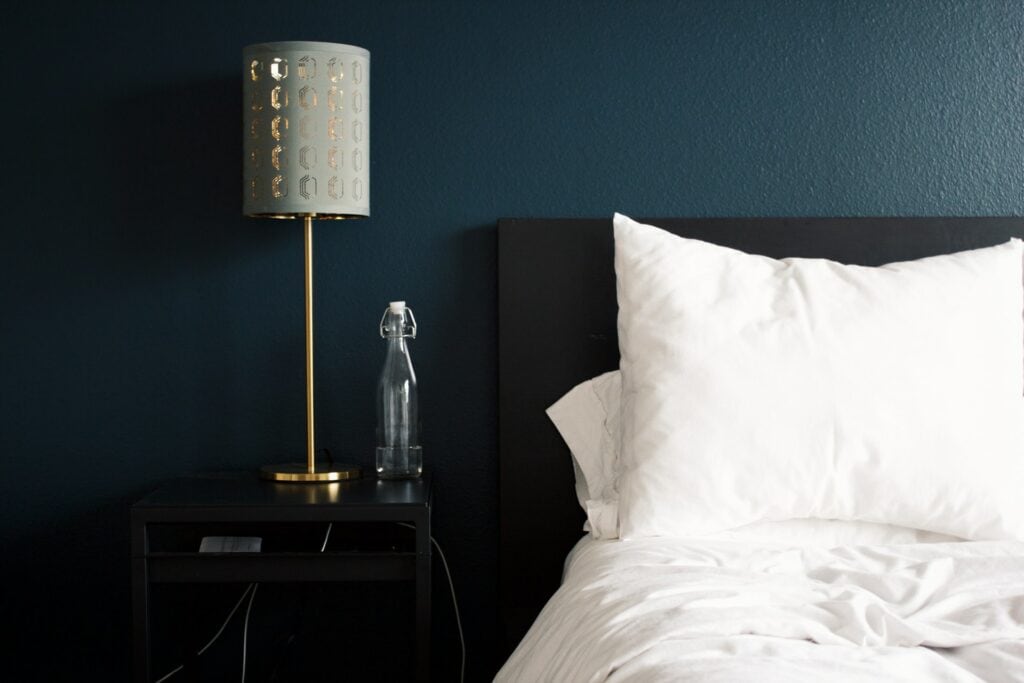 gray table lamp beside a white bed