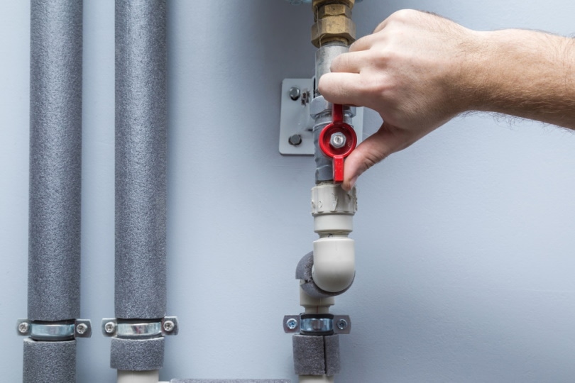 man holding water shut off valve