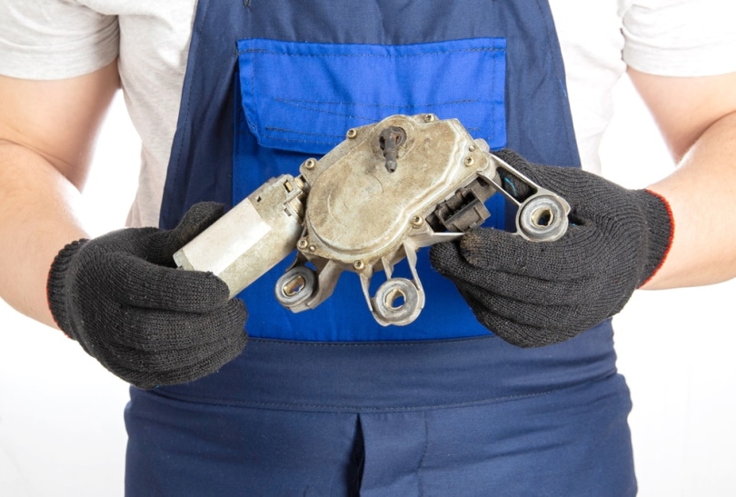man holding wiper motor