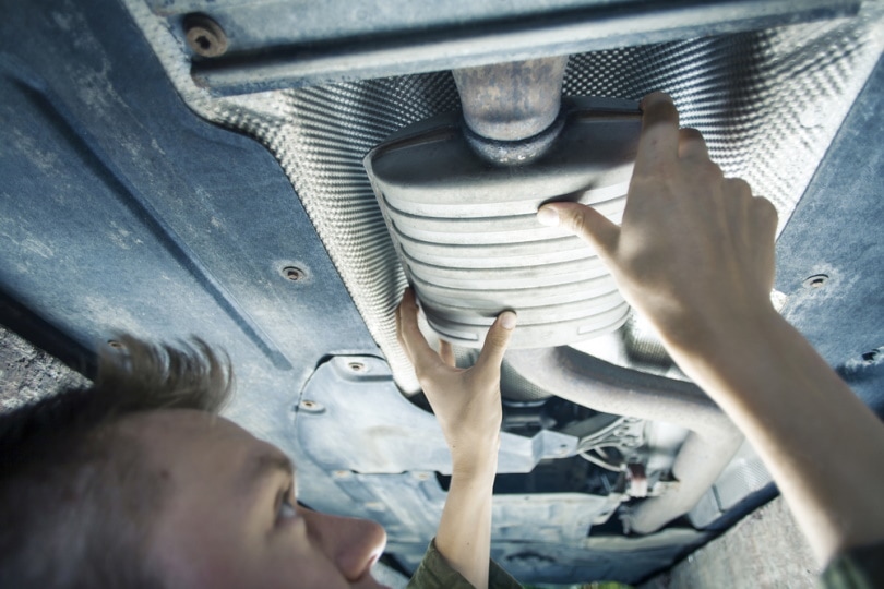 mechanic fixing car exhaust system