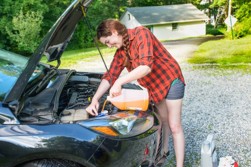 woman pouring wiper fluid