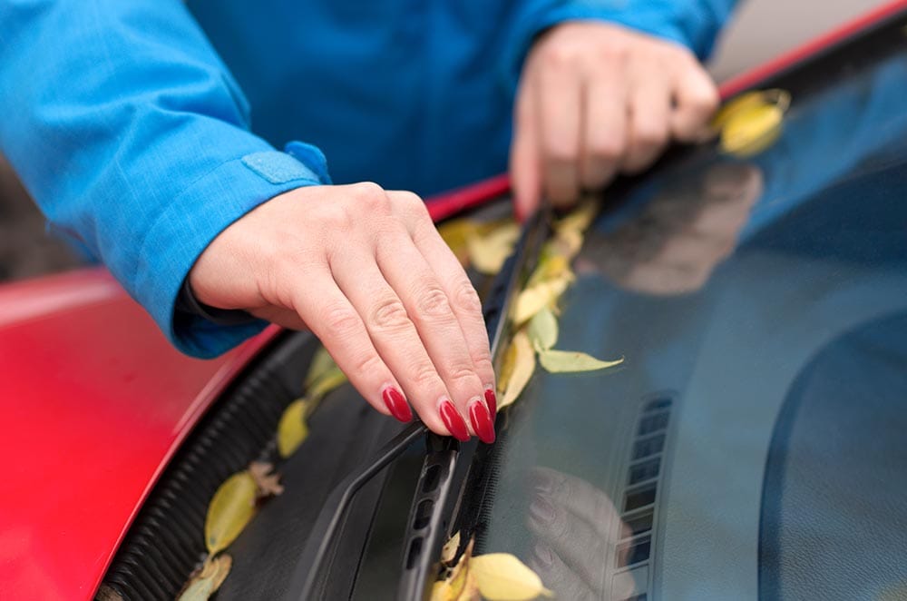 woman propping windshield wiper up
