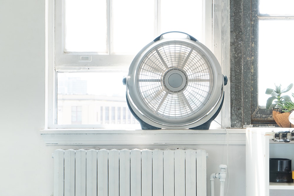 Mini fan near a window_010110010101101_Shutterstock