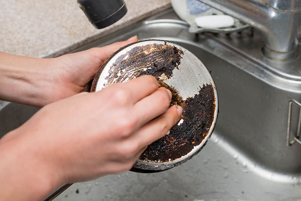 Scrubbing burned pot_Purino_Shutterstock