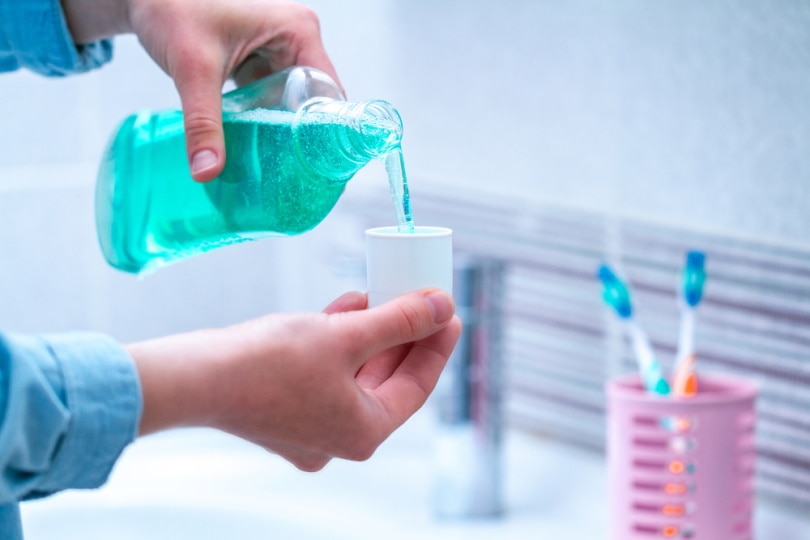 man using mouthwash