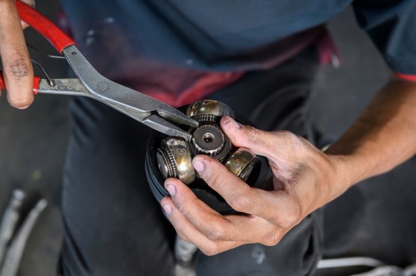 mechanic using snap ring pliers