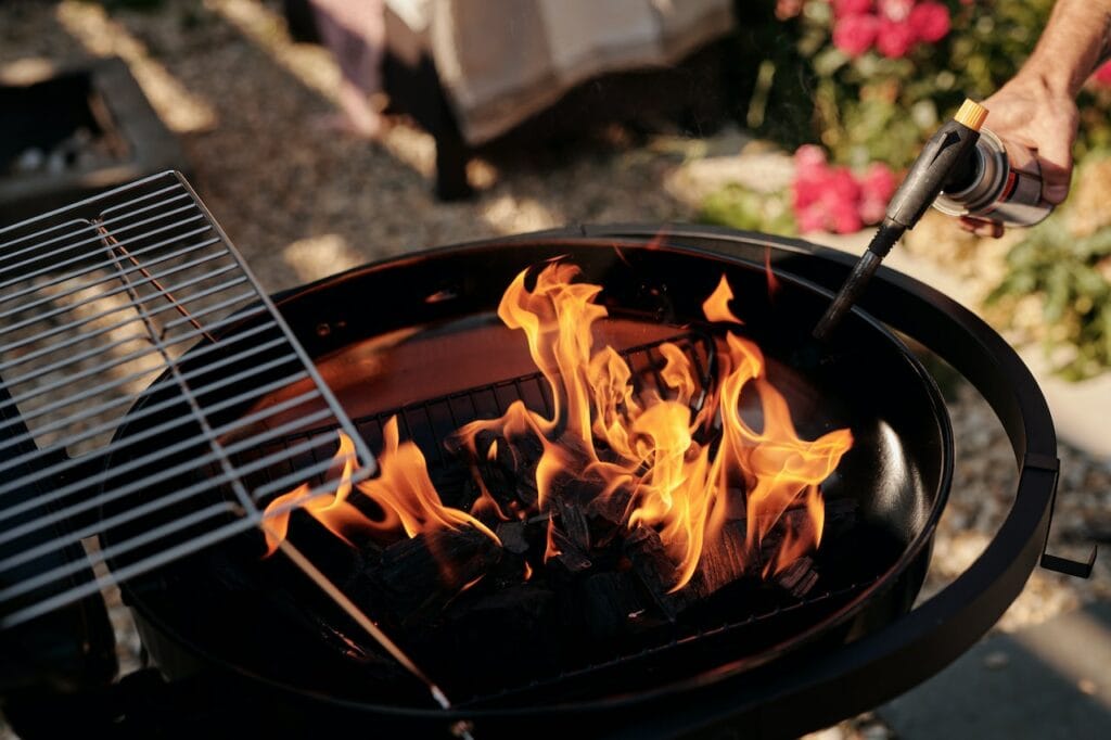 person burning coal of a griller