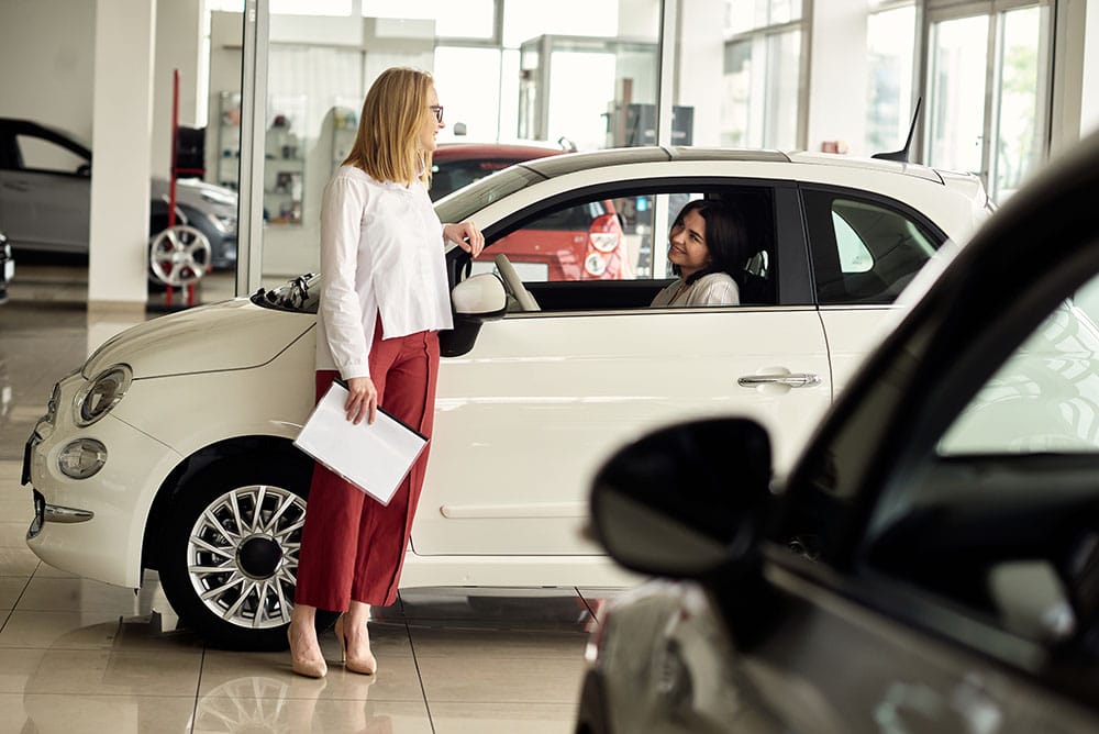 A girl in a car dealership buys a small city car
