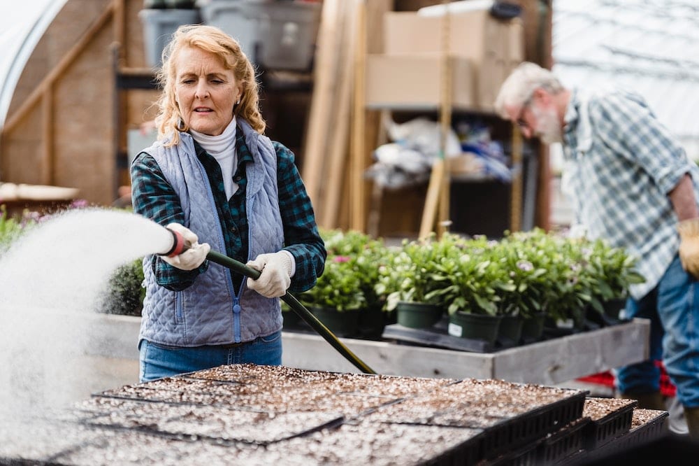 Elderly woman watering plants
