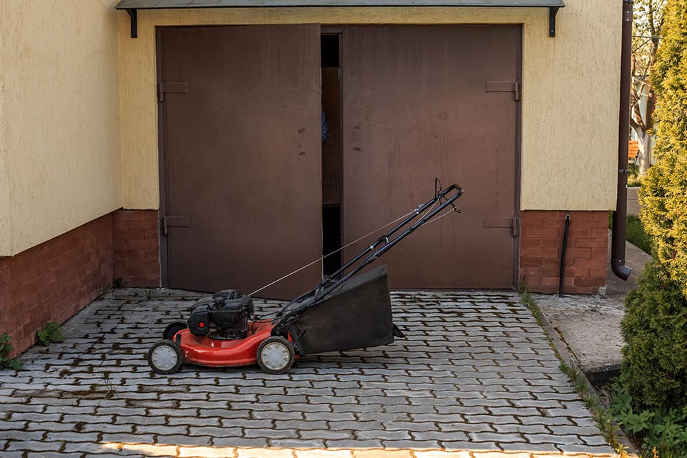 Lawn mower opposite the garage