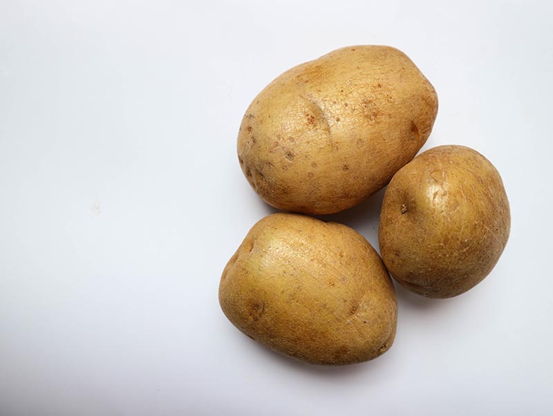 Raw potatoes on a white background