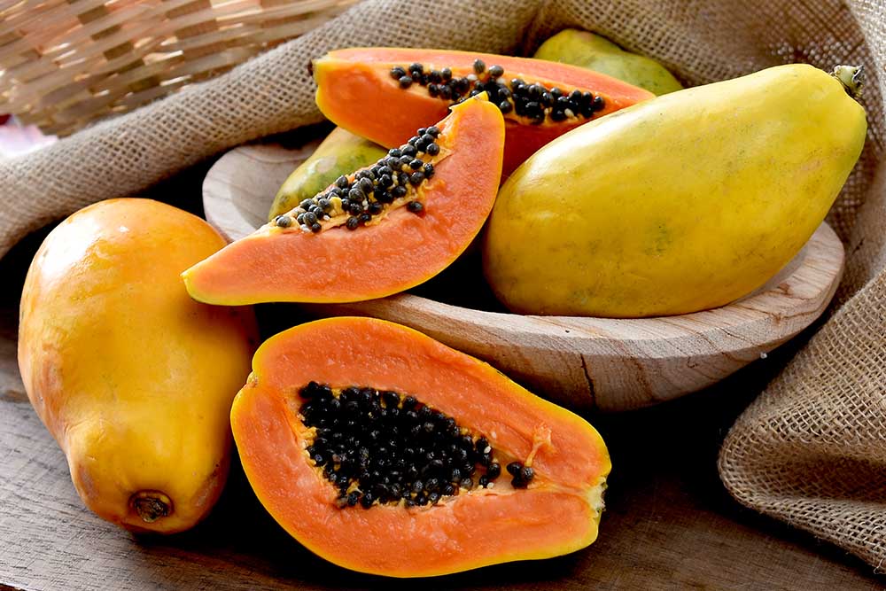The papaya fruits in a wooden pot and a straw basket