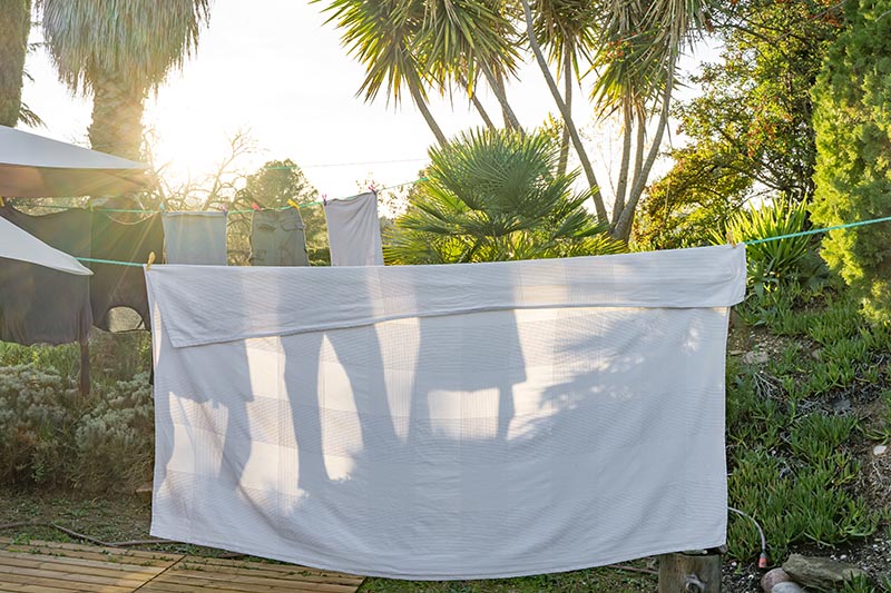 White and soft bedding sheet hanging on clothesline