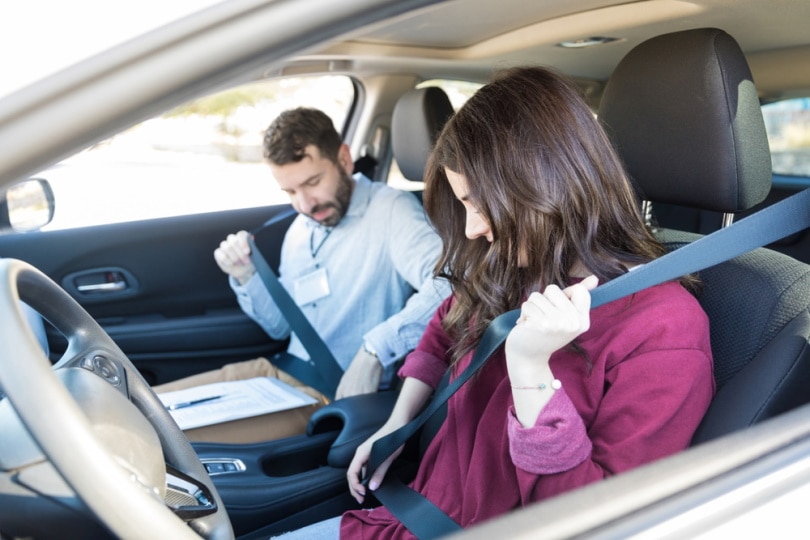 driver and passenger fastening seatbelts