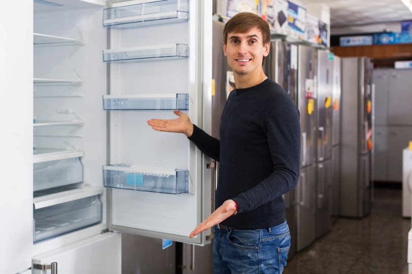 man choosing refrigerator in appliance store