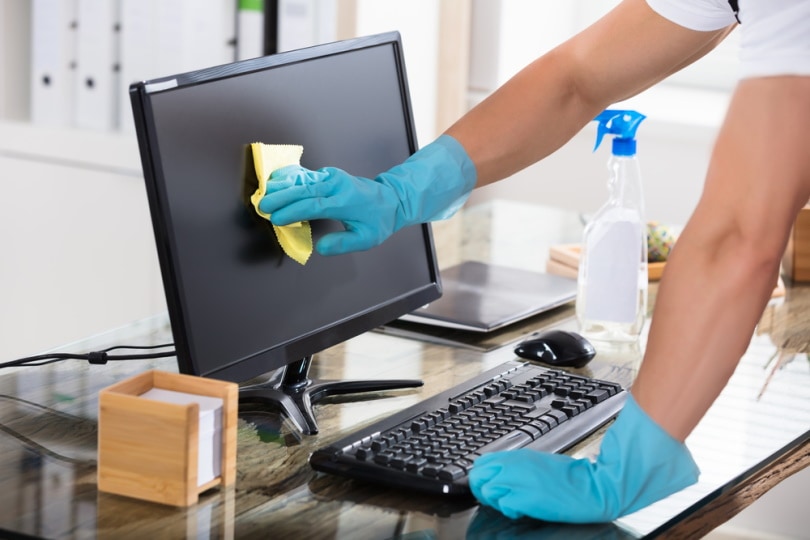 man cleaning computer screen