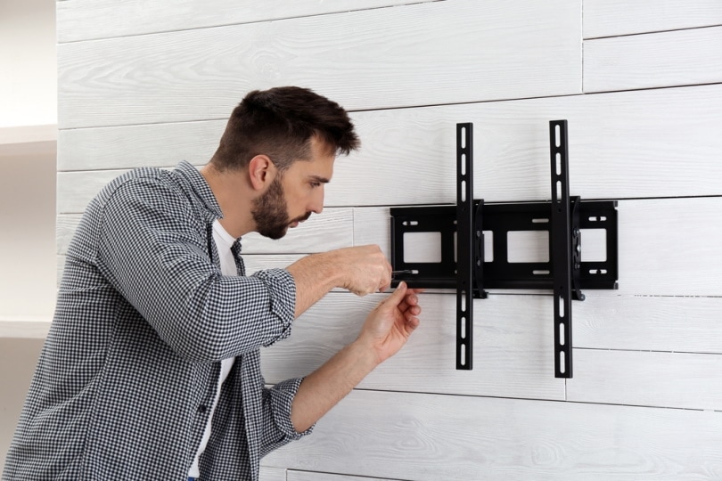 man installing TV bracket