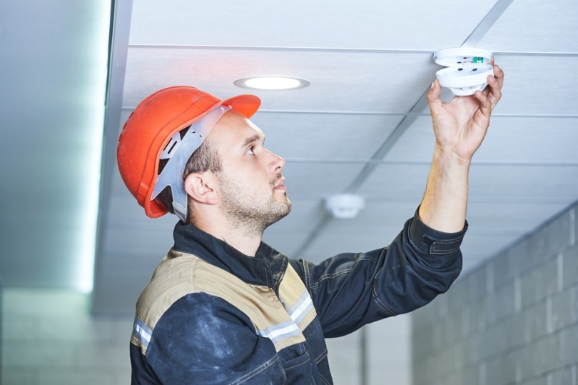 man installing smoke alarm