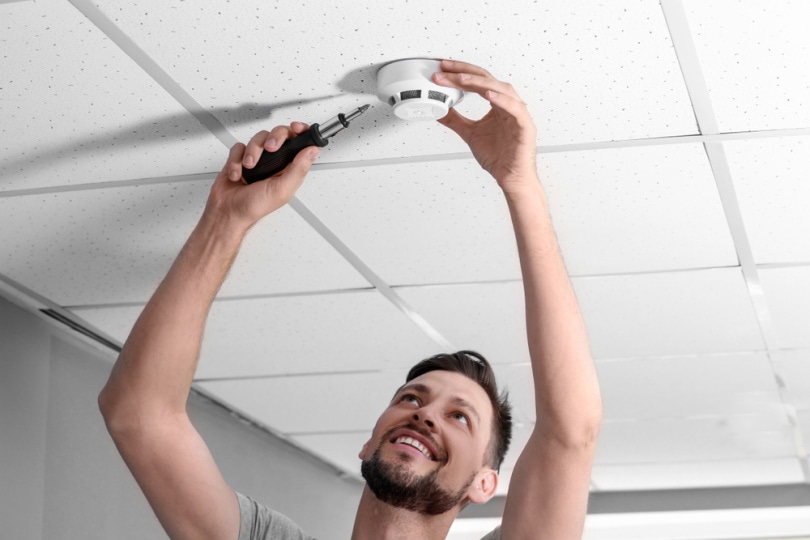 man installing smoke detector