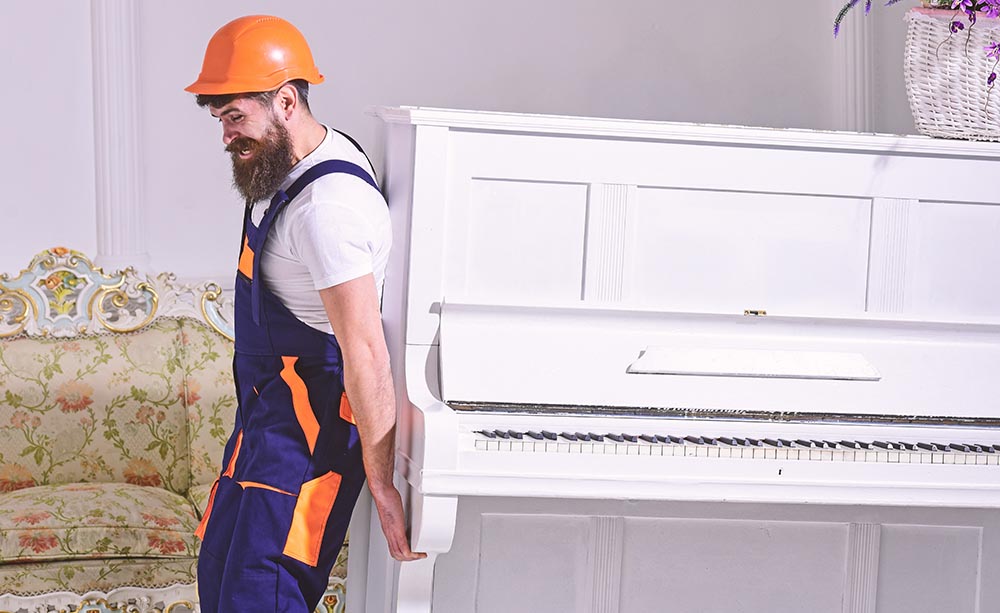 man moving piano alone