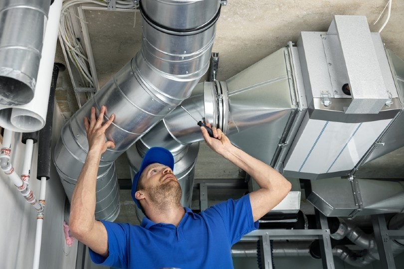 repairman taking a look at an industrial air duct