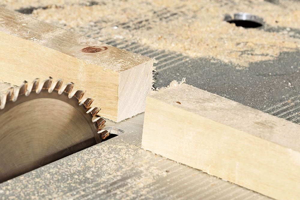 wooden bar is sawn with saw blade
