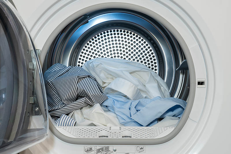 Clothes dryer with washed and dried shirts in and door open