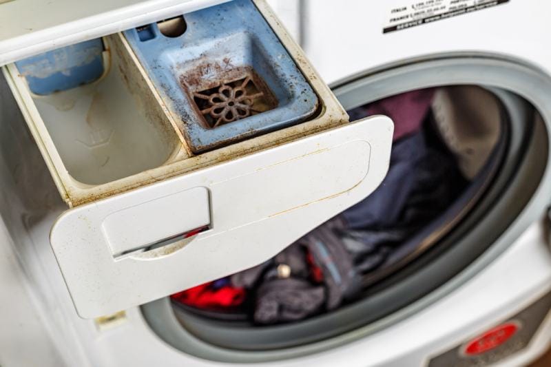 Dirty washing machine detergent and fabric conditioner dispenser drawer compartment