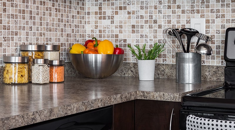 Food ingredients and green herbs on modern kitchen countertop