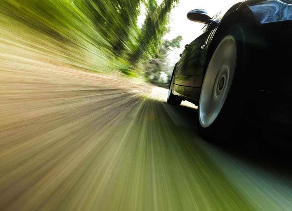 Front side view of black car driving fast