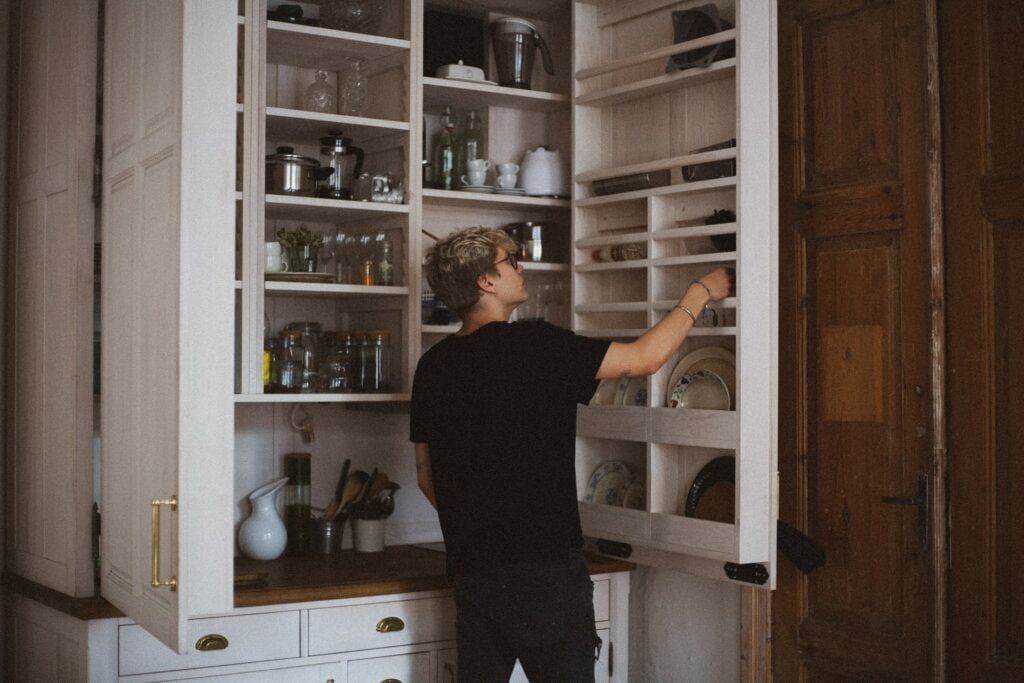 Man organizing kitchen cabinet