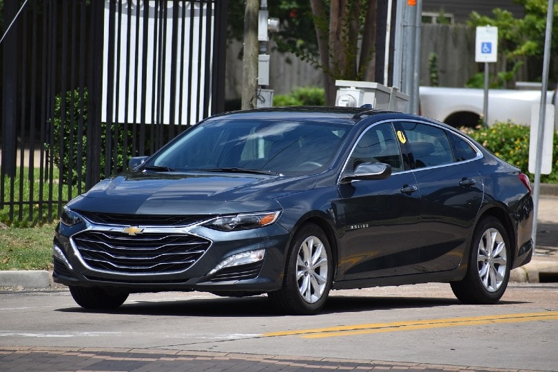 a black chevrolet sedan on the road