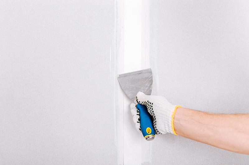 applying putty on drywall