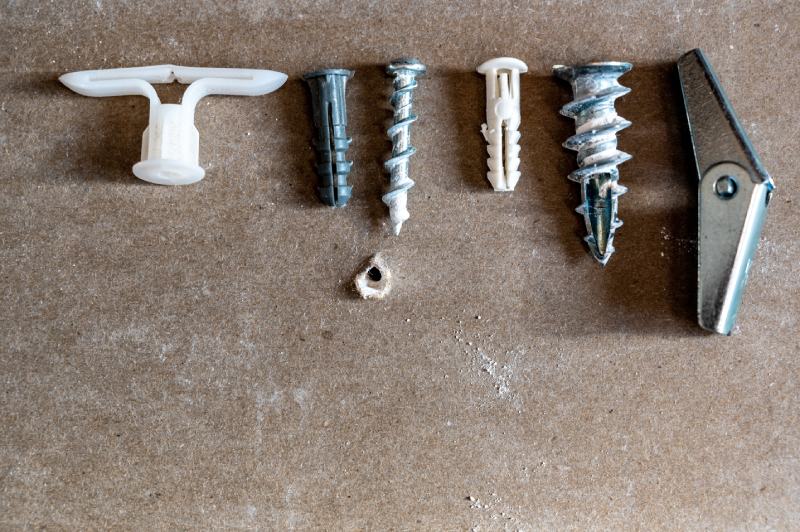 assortment of different drywall anchors used for hanging objects on walls