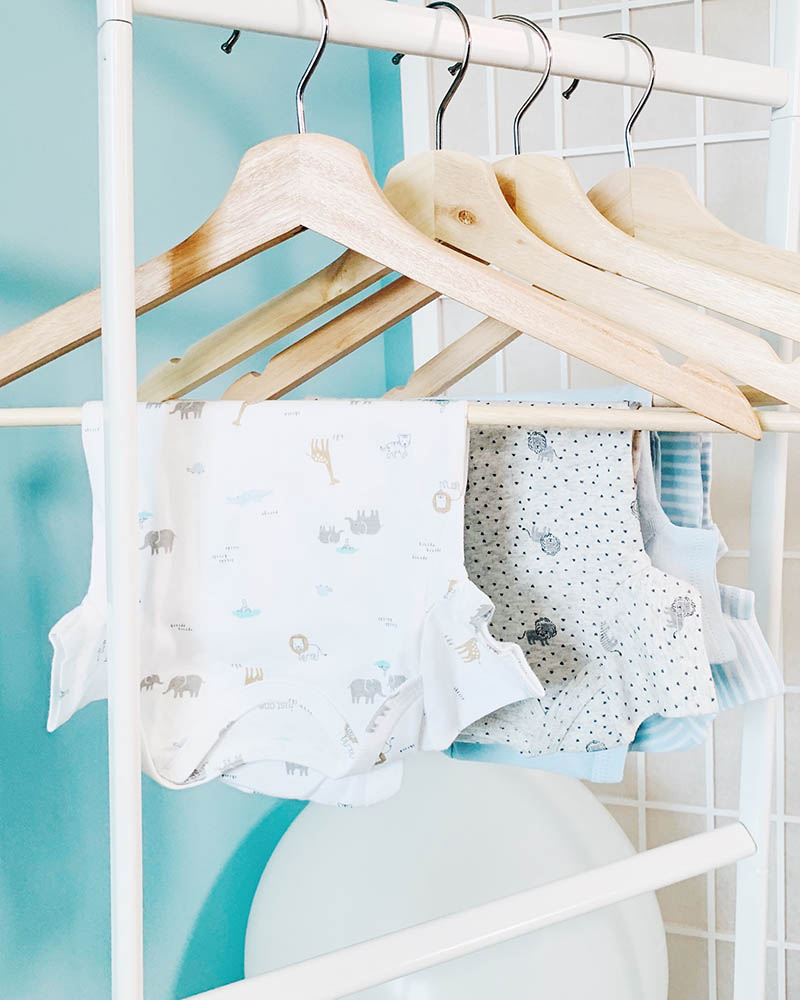 baby clothes hanging on a clothing rod