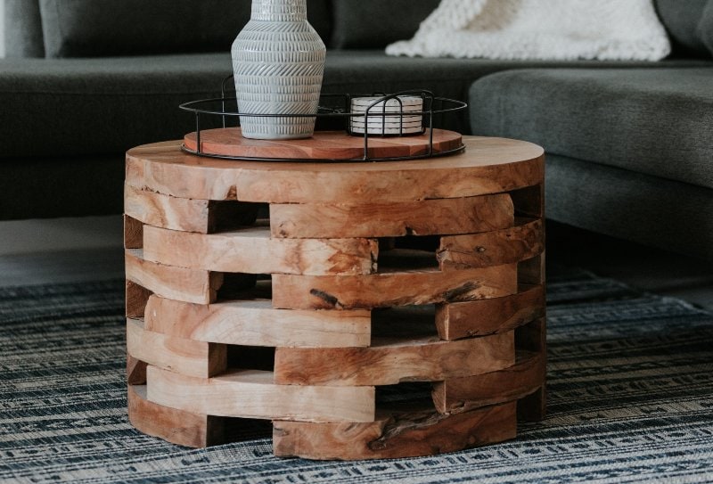 brown round wooden table in front of dark grey couch